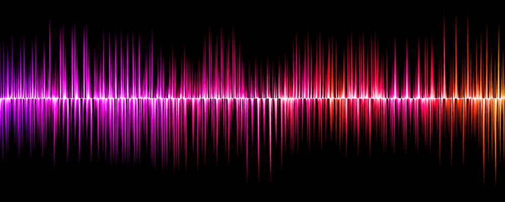 Abstract background of colorful vertical sound waves in blue, purple, pink, and red on a black background symbolising spectrum.