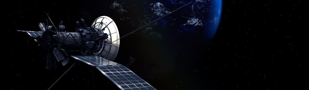 Satellite with solar panels and antenna against a dark background with Earth in the distance.