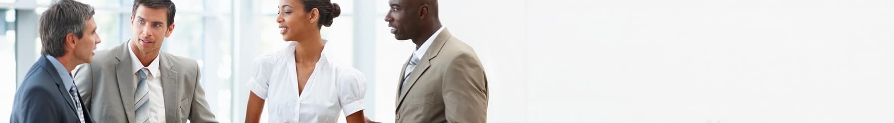 Four professionals conversing in an office